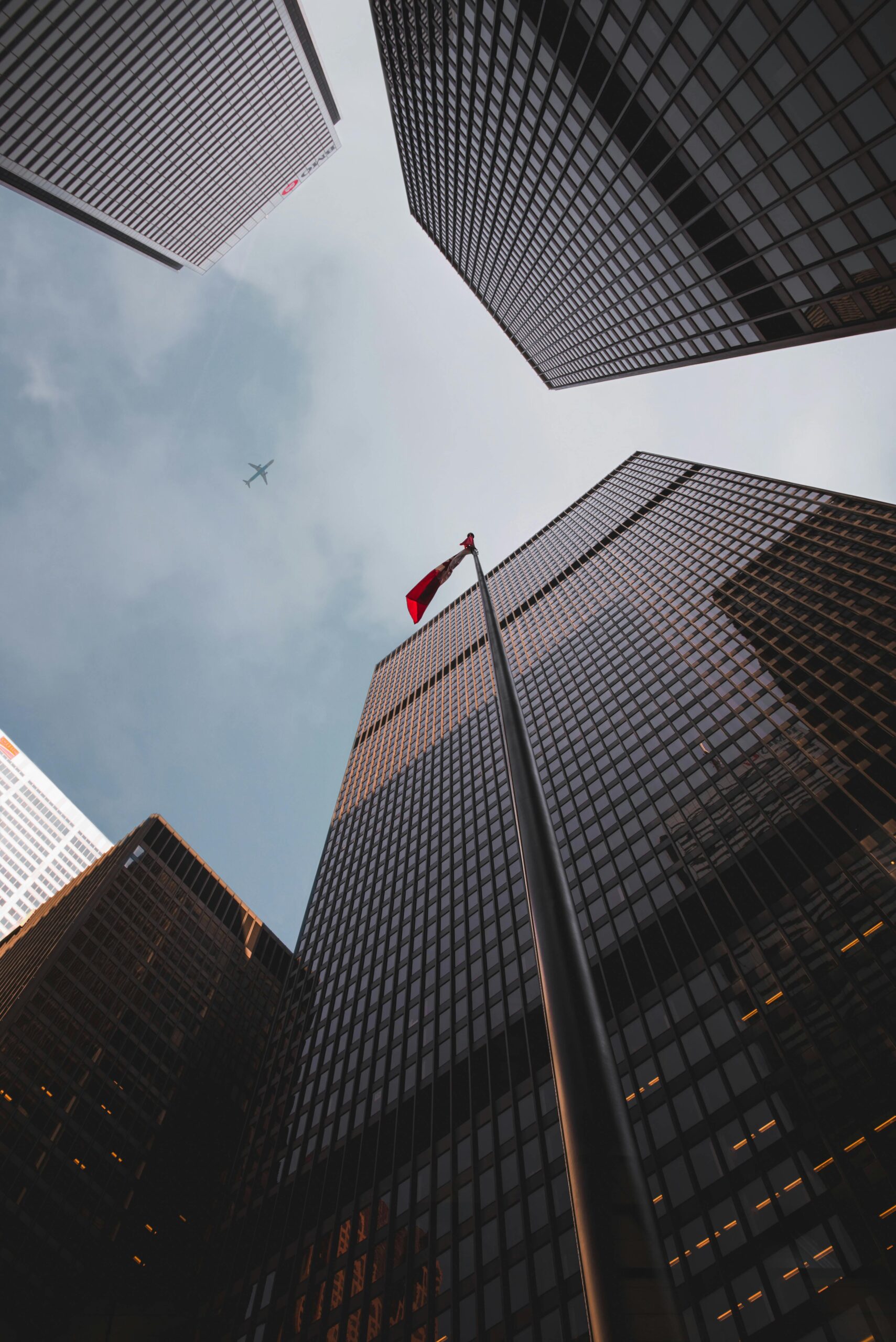Low angle of modern skyscrapers with a Canadian flag in downtown Toronto.